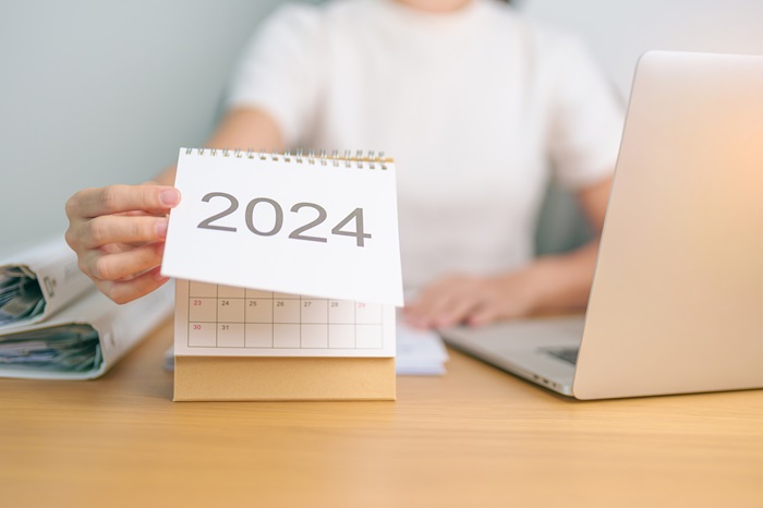 2024 Year Calendar on table with business woman using laptop 